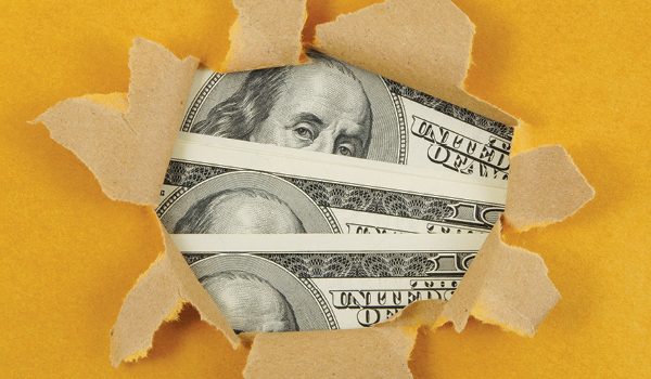 Paper torn open to show money behind it