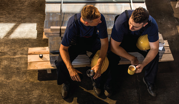Overhead view of two construction workers sitting and talking