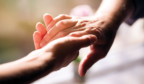 Close up of one hand holding another