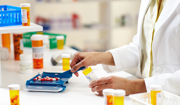 A pharmacist measuring/counting pills