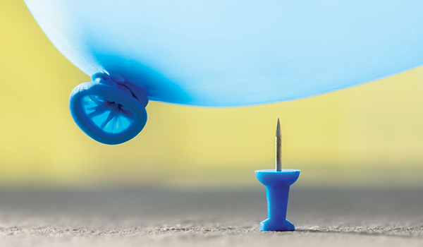 A balloon hovering above an upright tack